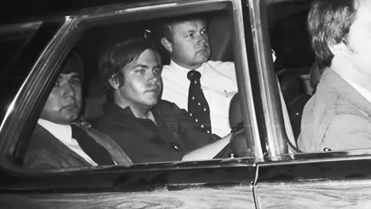 John Hinckley Junior being escorted in the back of a police car