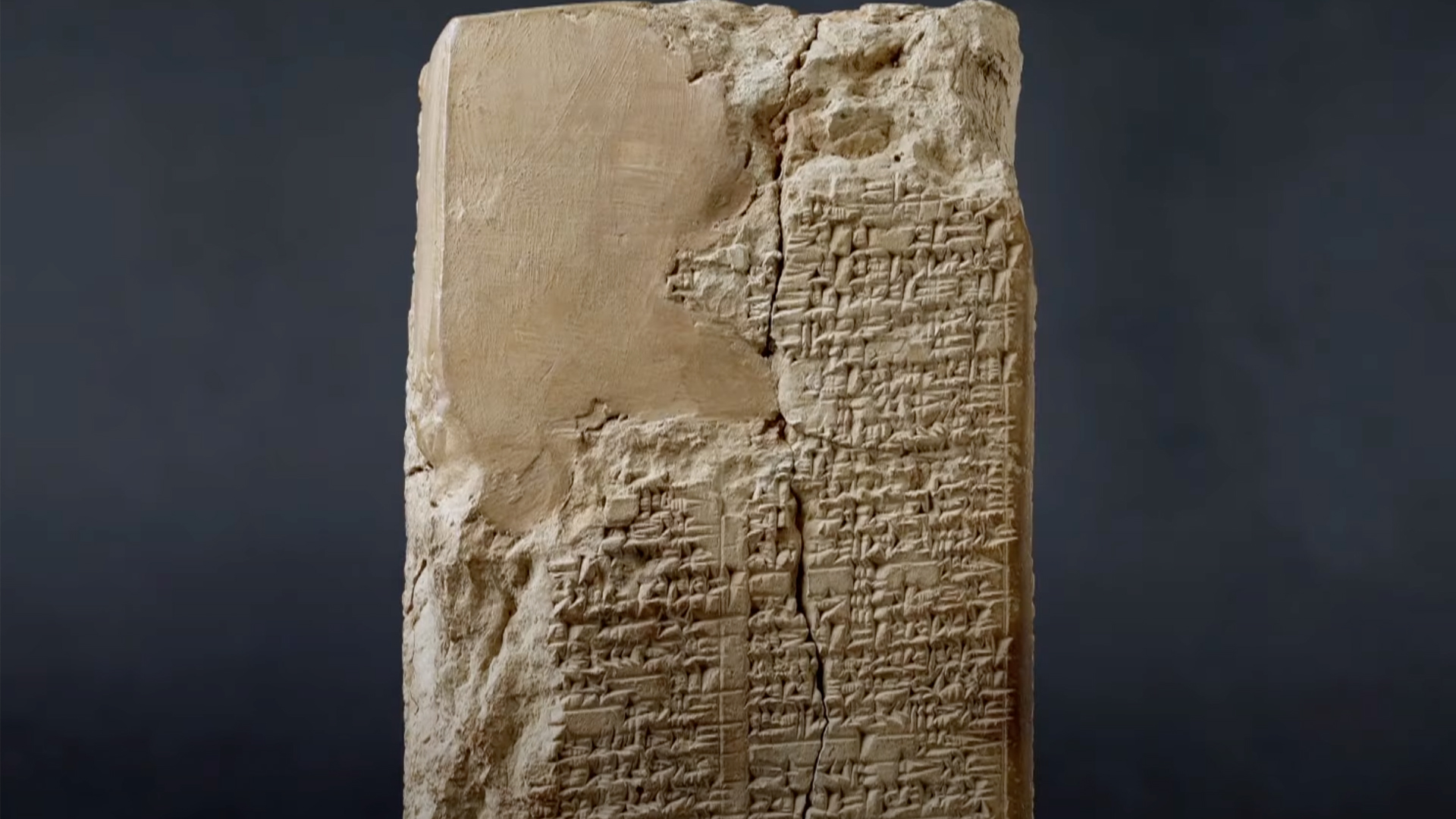 A large cuboid stone covered in ancient markings