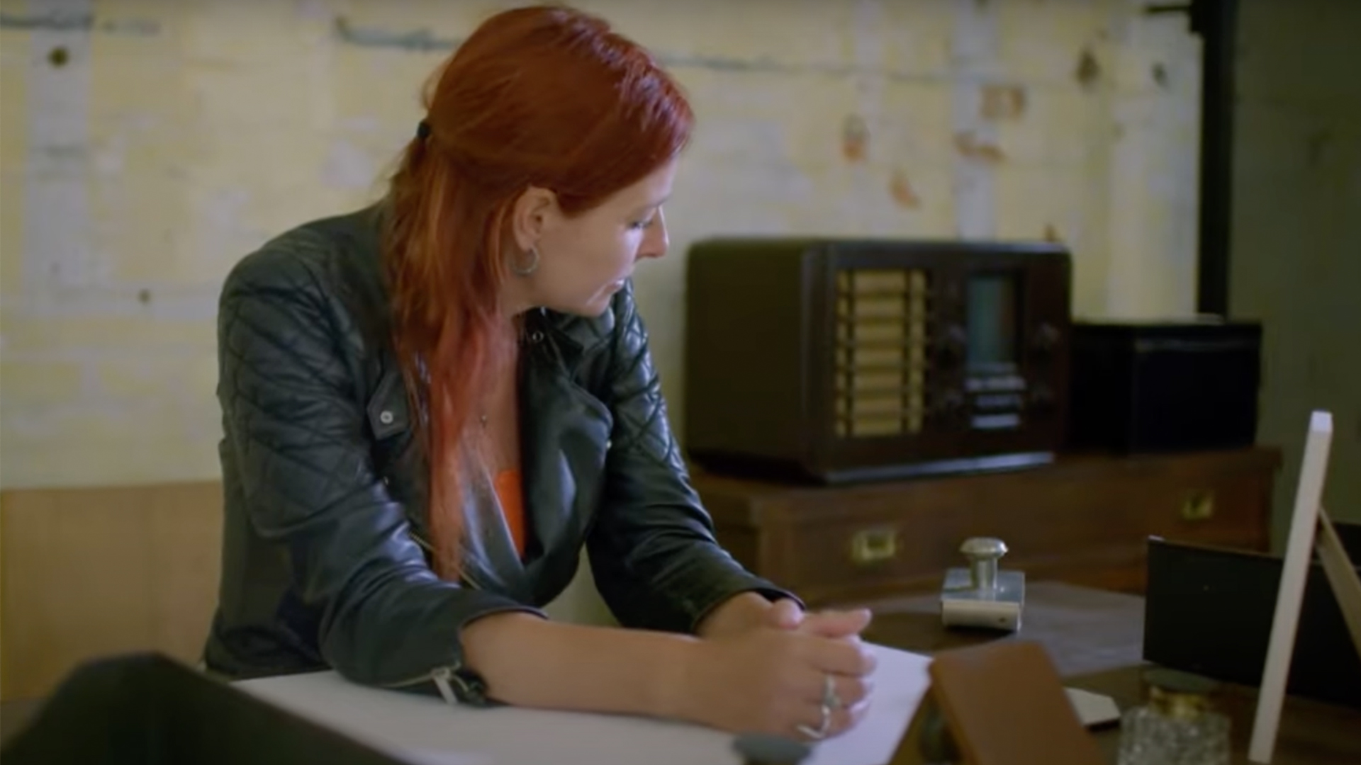 Alice Roberts sitting at a desk in a replica of a WW2 war room