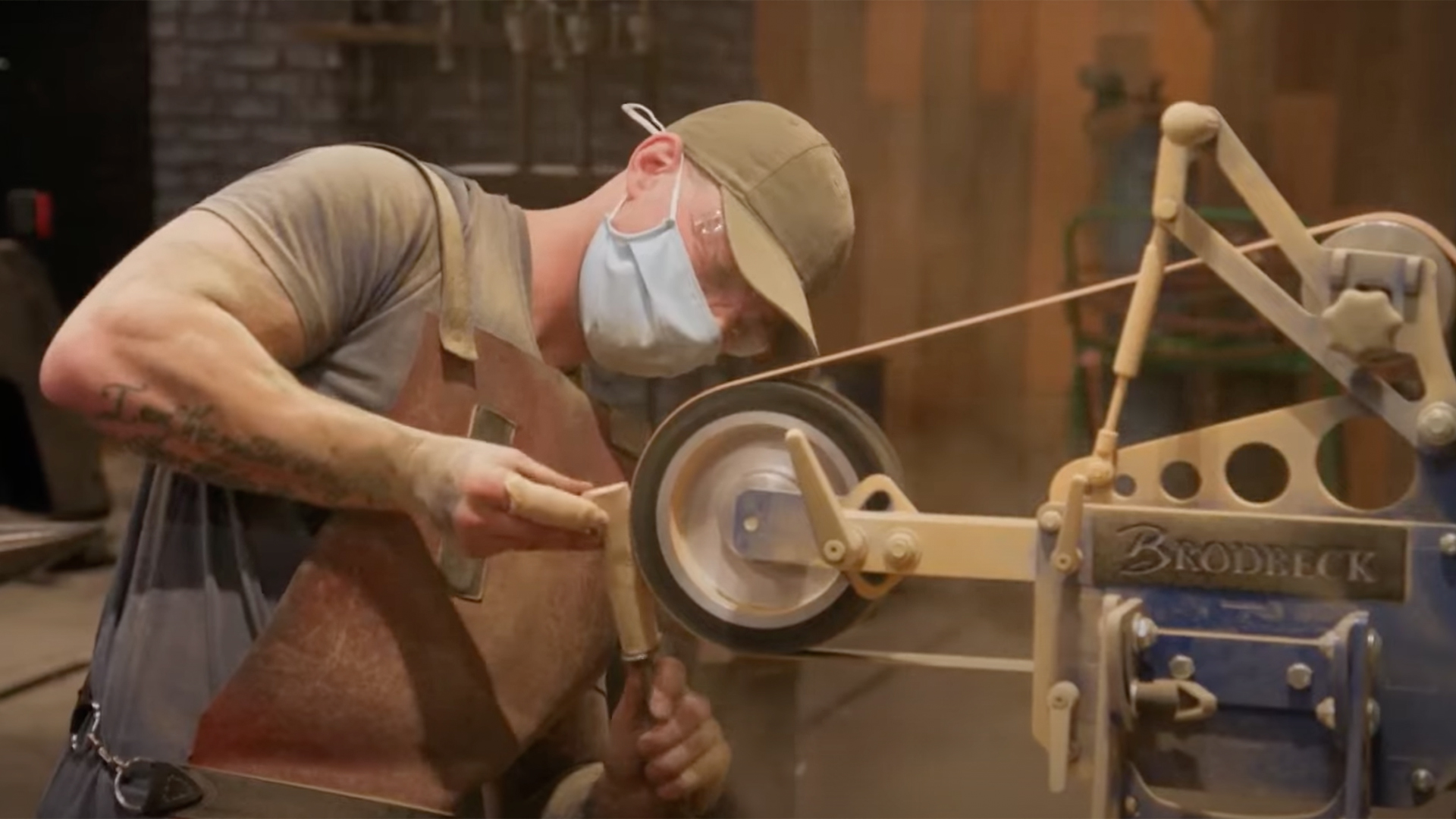 A Forged In Fire contestant uses a sanding machine