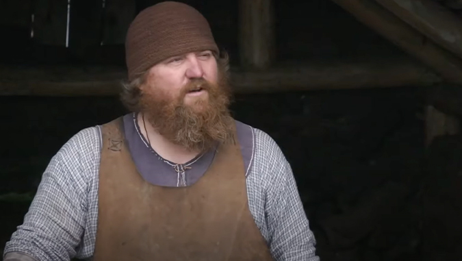 A man dressed as a Viking blacksmith