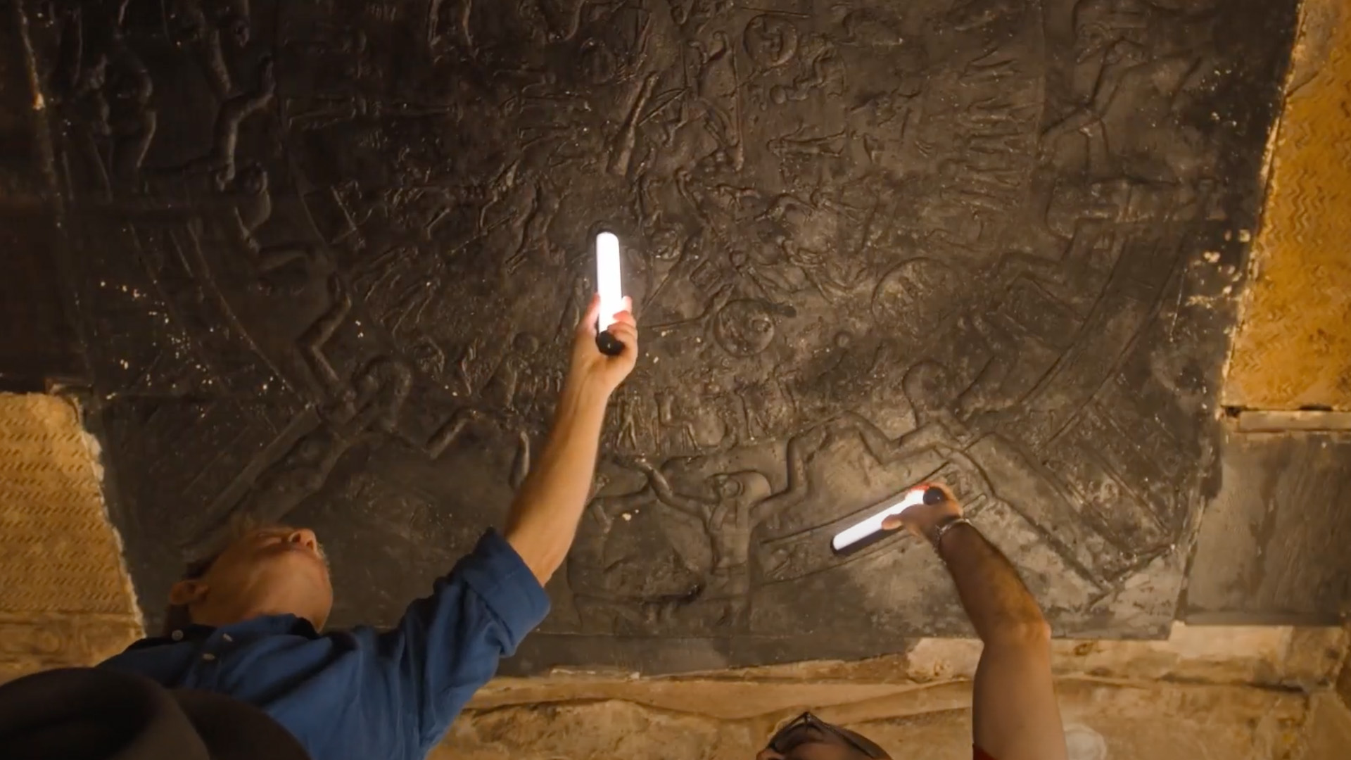 Bradley Walsh holds up a light bar to Ancient Egyptian hieroglyphics on the ceiling