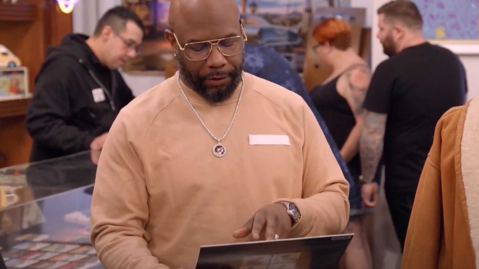 Boyz II Men member Michael McCary inspects a vinyl record in the Pawn Stars shop
