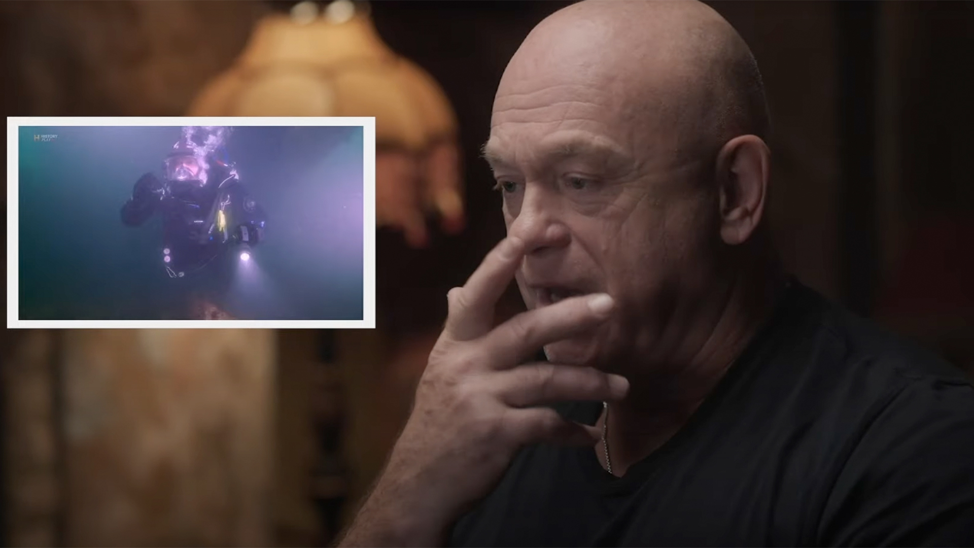 Ross Kemp holds a hand up to his mouth while a clip of him diving is shown in the inset