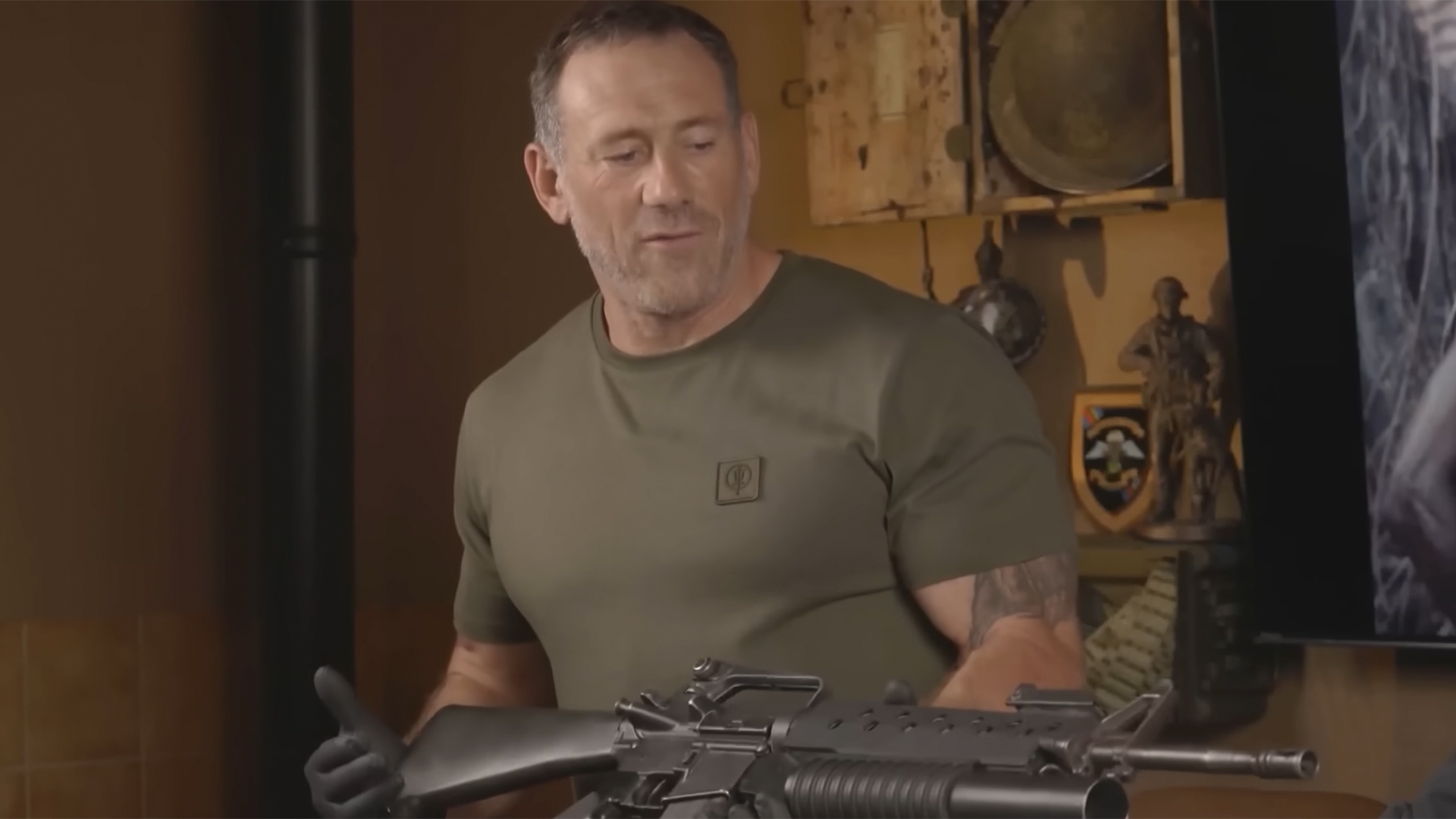 Jason Fox holding a large gun - the M16 rifle