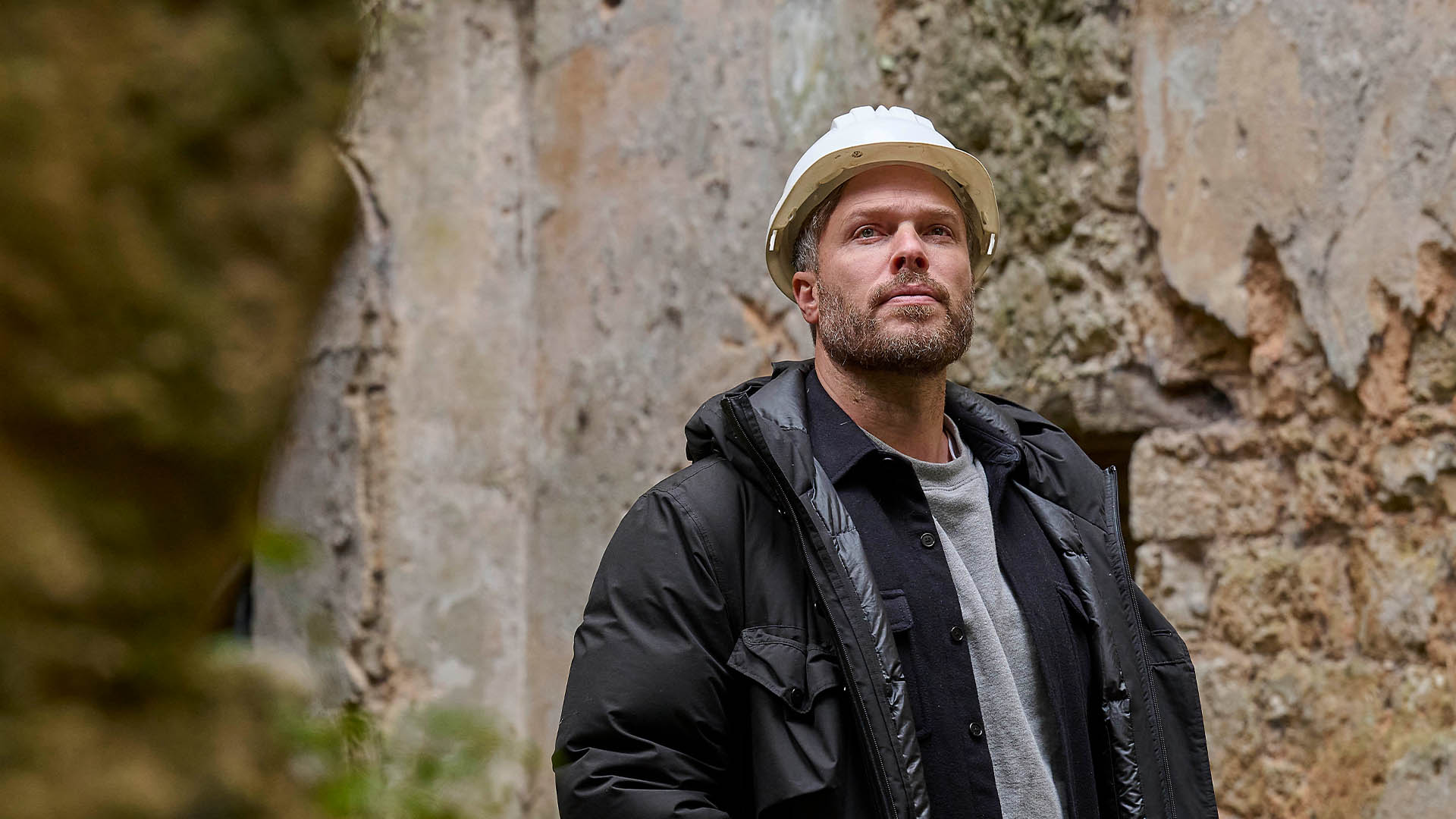 Rick Edwards wearing a hard hat in the ruins of a castle