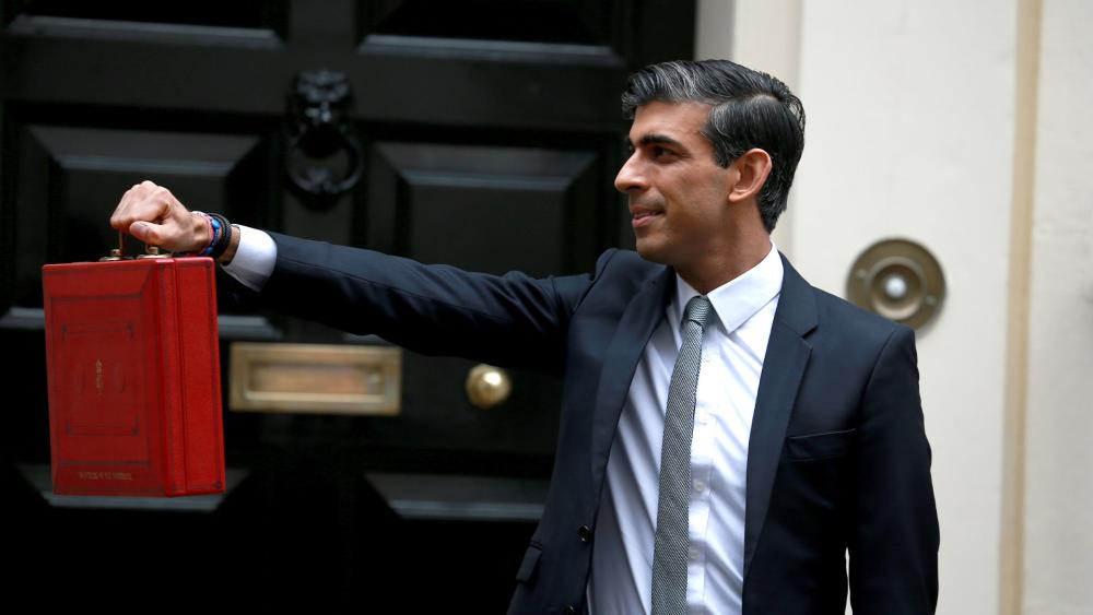 Rishi Sunak holding the red government dispatch box in front of 11 Downing Street in 2021