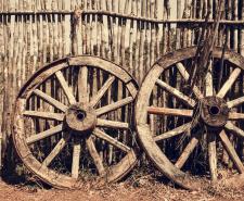 Two old wagon wheels near the wooden fence