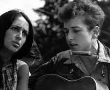 Bob Dylan with his guitar and attached harmonica with Joan Baez