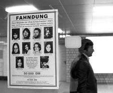 Black and white photograph showing poster in a German train station appealing for help in the capture of the Baader-Meinhog gang members