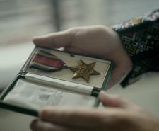 A man holding a Burma Star medal in a case