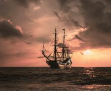 A pirate ship on the sea at sunset