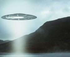 A UFO hovering over a mountain lake with a light beam coming down