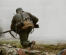 A soldier taking part in a historical reenactment of a WWII fight
