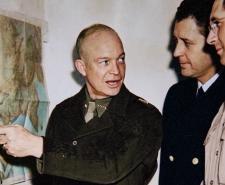 General Dwight Eisenhower points to a map during Operation Torch planning in World War II as military staff look on.