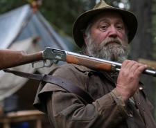 Randy from the new season of Mountain Men with a rifle across his shoulder