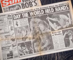 Double-page spread inside a newspaper showing pictures from the concert