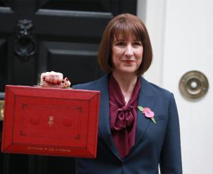 Rachel Reeves holding the red government dispatch box in front of 11 Downing Street in 2024