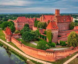 Malbork Castle in Poland made of red brick and next to the river