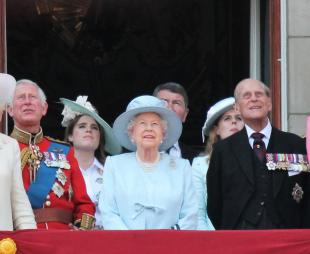 Members of the royal family, including Queen Elizabeth II, Prince Philip, King Charles III, Queen Camilla and Catherine, Princess of Wales stand of the balcony of Buckingham Palace and look at the sky