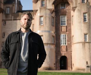 Rick Edwards standing in front of Fyvie Castle