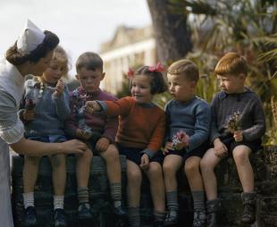 Five child evacuees speak with a nurse