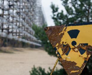 A partially corroded radiation warning sign in Chernobyl