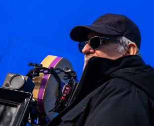 Steven Spielberg using a camera in front of a blue screen