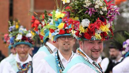 Morris dancers wearing floral headdresses 