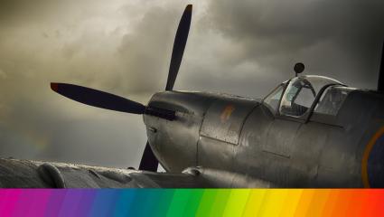 WWII fighter plane with a rainbow banner overlayed