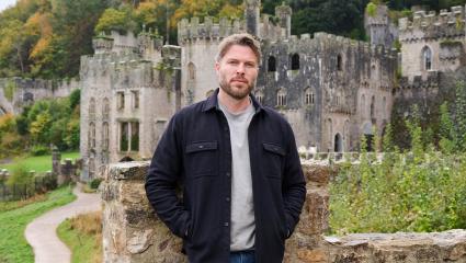 Rick Edwards standing in front of Gwrych Castle