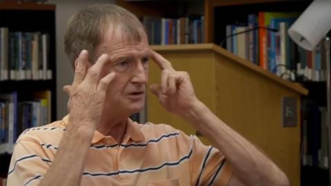 Edd Edwards hold his fingers to each side of his temple