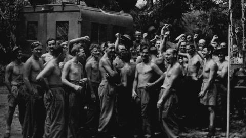 Black and white photograph of British troops in Burma celebrating after hearing the news of the Japanese surrender