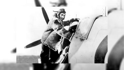 Black and white photograph of pilot Diana Barnato Walker climbing into the cockpit of a Spitfire