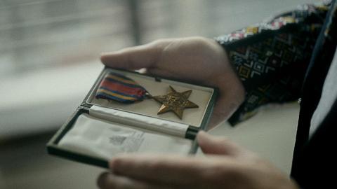 A man holding a Burma Star medal in a case