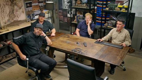 (From L-R) Bryant ‘Dragon’ Arnold, Kaleb Bench, Dr Travis Taylor and Erik Bard sitting around a large table looking at something on the wall