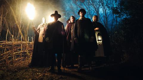 Actors portraying Matthew Hopkins and John Stearne lead a mob to arrest a witch