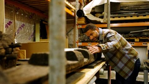 Sean Fletcher inspecting a large piece of timber