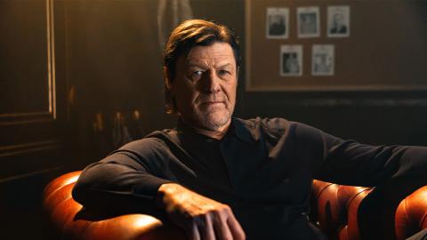 Sean Bean sitting in a large leather armchair