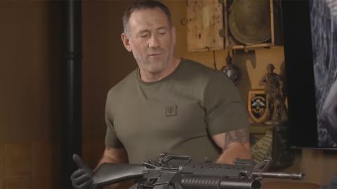 Jason Fox holding a large gun - the M16 rifle