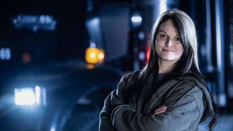 Lisa Kelly standing with her arms crossed in front of a truck