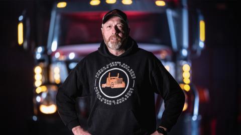 Shaun Harris stands with his hands on his hips in front of a large truck