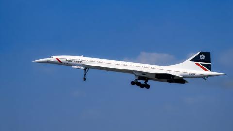 A Concorde plane belonging to British Airways taking off against a blue sky