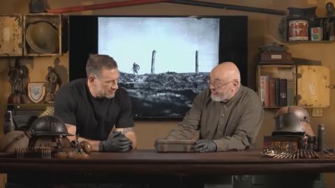 Foxy and Bruce inspecting an old container in front of an image from WWII