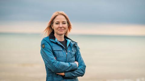 Alice Roberts standing by the sea