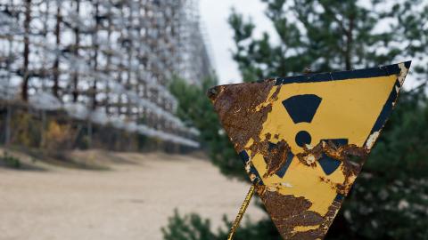 A partially corroded radiation warning sign in Chernobyl