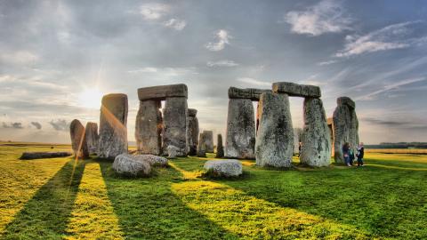 The sun behind Stonehenge