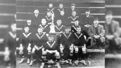 Team photo of West Auckland FC with the trophy they won in 1909