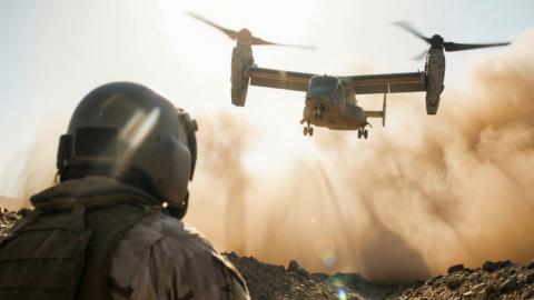 Military tiltrotor aircraft lands in a dusty desert as a soldier watches, from History’s Greatest Machines with Dolph Lundgren.