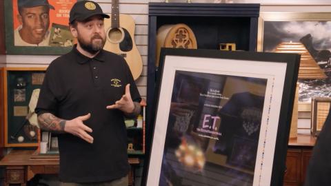 Chumlee standing next to a movie poster for E.T